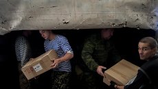 Мужчины разгружают один из грузовиков гуманитарной колонны на Украине. Архивное фото Мужчины разгружают один из грузовиков гуманитарной колонны на Украине. Архивное фото