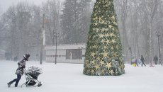Женщина с коляской во время снегопада в Москве Женщина с коляской во время снегопада в Москве