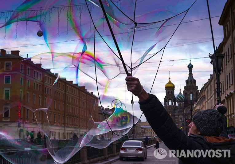 Уличный артист надувает мыльные пузыри на набережной канала Грибоедова в Санкт-Петербурге Уличный артист надувает мыльные пузыри на набережной канала Грибоедова в Санкт-Петербурге