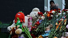 Цветы и игрушки в память об убитой девочке возле подъезда дома на улице Народного ополчения в Москве