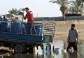 Люди собирают воду в реке. Багдад, Ирак Люди собирают воду в реке. Багдад, Ирак