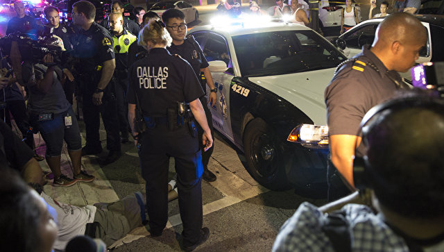 Полицейские и местные жители после стрельбы в центре Далласа. 7 июля 2016 Полицейские и местные жители после стрельбы в центре Далласа. 7 июля 2016