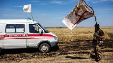 Украинский военный с белым флагом во время передачи убитых на нейтральной территории вблизи поселка Диброво Украинский военный с белым флагом во время передачи убитых на нейтральной территории вблизи поселка Диброво