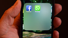 Иконки WhatsApp и Facebook на экране смартфона. Архивное фото Иконки WhatsApp и Facebook на экране смартфона. Архивное фото