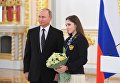 Президент РФ Владимир Путин и серебряный и бронзовый призер по спортивной гимнастике Алия Мустафина на церемонии вручения государственных наград победителям и призерам Олимпийских игр Президент РФ Владимир Путин и серебряный и бронзовый призер по спортивной гимнастике Алия Мустафина на церемонии вручения государственных наград победителям и призерам Олимпийских игр