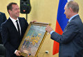 Президент РФ Владимир Путин дарит председателю правительства РФ Дмитрию Медведеву на его день рождения картину "В цеху". 15 сентября 2016