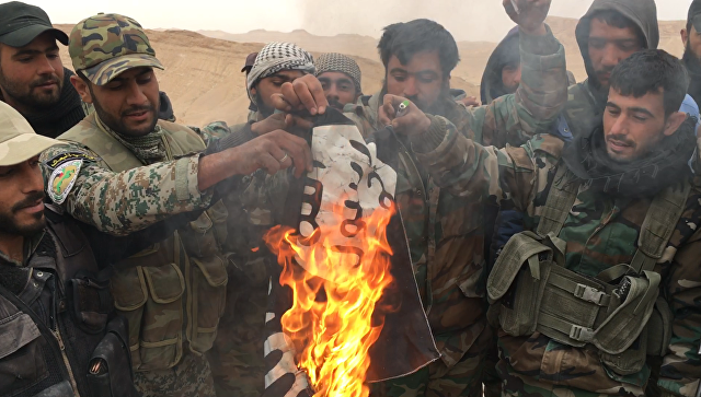 Сирийские солдаты сжигают флаг террористической группировки Исламское государство, архивное фото