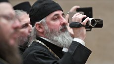 Священник с видеокамерой Священник с видеокамерой
