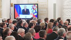 Экран с трансляцией выступления президента России Владимира Путина с ежегодным посланием Федеральному Собранию РФ в Георгиевском зале Кремля. 1 декабря 2016 Экран с трансляцией выступления президента России Владимира Путина с ежегодным посланием Федеральному Собранию РФ в Георгиевском зале Кремля. 1 декабря 2016