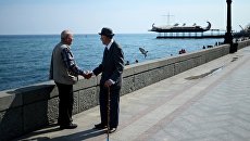 Пожилые люди на набережной в Ялте. Архивное фото Пожилые люди на набережной в Ялте. Архивное фото
