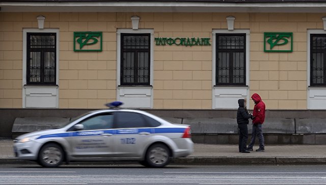 Автомобиль полиции едет мимо здания в Москве, в котором расположен офис Татфондбанка. Архивное фото