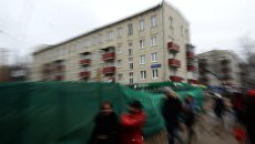 Прохожие идут мимо пятиэтажных жилых домов. Архивное фото Прохожие идут мимо пятиэтажных жилых домов. Архивное фото