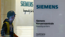 Рабочий у входа в штаб-квартиру компании Siemens в Мюнхене, Германия. Архивное фото Рабочий у входа в штаб-квартиру компании Siemens в Мюнхене, Германия. Архивное фото
