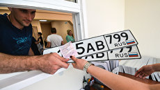 Выдача автовладельцу номерных знаков. Архивное фото Выдача автовладельцу номерных знаков. Архивное фото