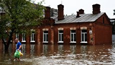 Мужчина на затопленной улице Уссурийска. Архивное фото Мужчина на затопленной улице Уссурийска. Архивное фото