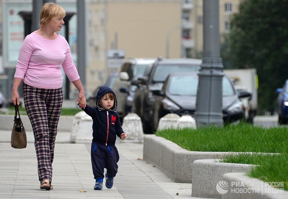 Женщина с ребенком идут по улице Житная в Москве Женщина с ребенком идут по улице Житная в Москве