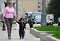 Женщина с ребенком идут по улице Житная в Москве Женщина с ребенком идут по улице Житная в Москве