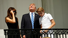 Дональд Трамп смотрит на солнечное затмение с балкона Белого дома Дональд Трамп смотрит на солнечное затмение с балкона Белого дома