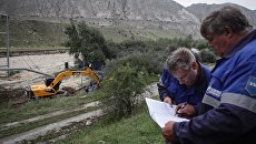 Сотрудники Газпрома возле поврежденного сходом селя газопровода в Республике Кабардино-Балкария. Архивное фото Сотрудники Газпрома возле поврежденного сходом селя газопровода в Республике Кабардино-Балкария. Архивное фото