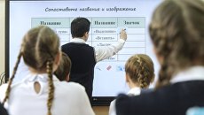 Ученик выполняет задание возле интерактивной доски Ученик выполняет задание возле интерактивной доски