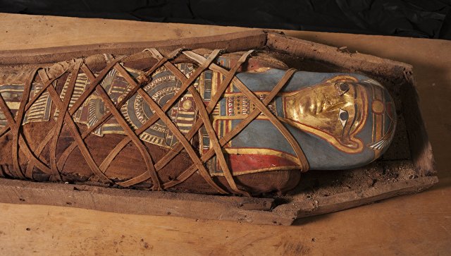 A mummy with a gilded cardboard mask in a wooden sarcophagus, found during archaeological research conducted by the CEI RAS on the Deir el-Banat monument in Fayoum oasis of Egypt