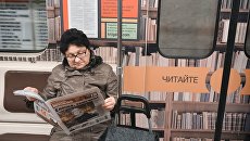 Женщина читет газету в метро. Архивное фото Женщина читет газету в метро. Архивное фото