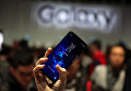 Девушка держит новый смартфон Samsung Galaxy S9 после презентации Mobile World Congress в Барселоне, Испания. 25 февраля 2018 года Девушка держит новый смартфон Samsung Galaxy S9 после презентации Mobile World Congress в Барселоне, Испания. 25 февраля 2018 года