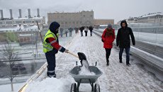 Сотрудник коммунальных служб во время уборки последствий снегопада на Парящем мосту парка Зарядье в Москве Сотрудник коммунальных служб во время уборки последствий снегопада на Парящем мосту парка Зарядье в Москве