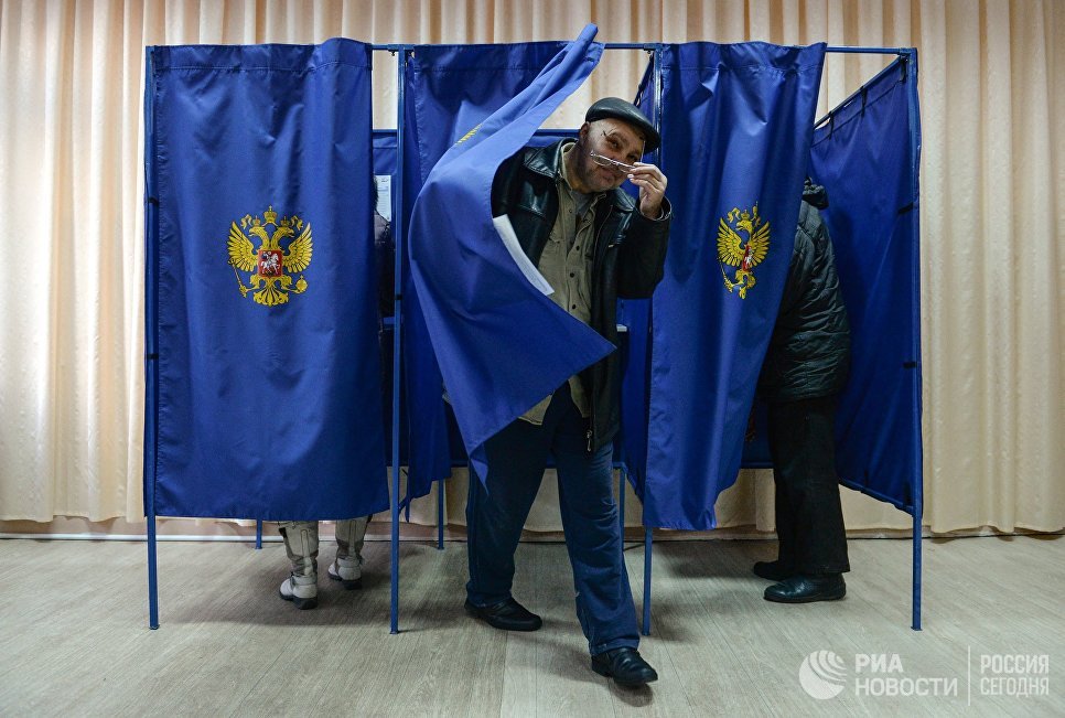 Мужчина выходит из кабинки во время голосования на выборах президента Российской Федерации на избирательном участке в Новосибирске. 18 марта 2018