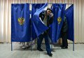 Мужчина выходит из кабинки во время голосования на выборах президента Российской Федерации на избирательном участке в Новосибирске. 18 марта 2018 Мужчина выходит из кабинки во время голосования на выборах президента Российской Федерации на избирательном участке в Новосибирске. 18 марта 2018