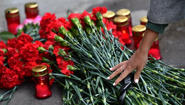 Цветы и свечи в память о погибших в ТЦ Зимняя вишня у здания представительства Кемеровской области в Москве. 26 марта 2018