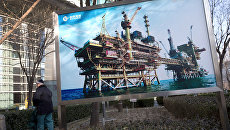 Баннер с изображением китайской нефтяной платформы компании CNOOC в Пекине. Архивное фото Баннер с изображением китайской нефтяной платформы компании CNOOC в Пекине. Архивное фото