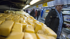 Сырная продукция на прилавке магазина. Архивное фото Сырная продукция на прилавке магазина. Архивное фото