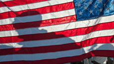 Военный на фоне флага США. Архивное фото Военный на фоне флага США. Архивное фото