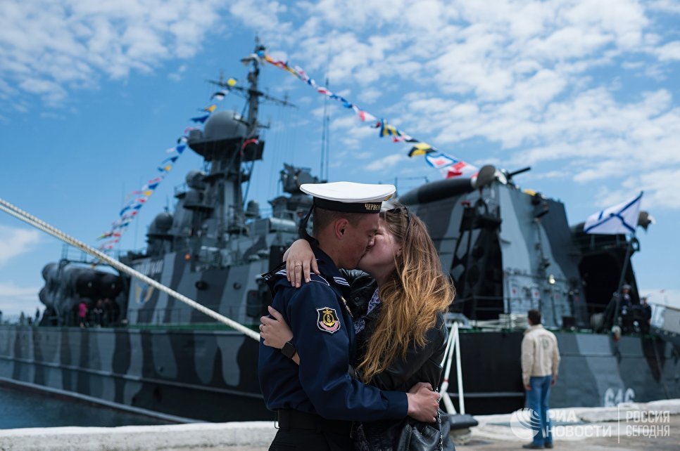 Моряк Черноморского флота с девушкой во время праздничных мероприятий в Севастополе Моряк Черноморского флота с девушкой во время праздничных мероприятий в Севастополе