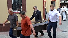 Люди несут гроб с телом прихожанина Артемия, погибшего при нападении на храм Архангела Михаила в Грозном. Архивное фото Люди несут гроб с телом прихожанина Артемия, погибшего при нападении на храм Архангела Михаила в Грозном. Архивное фото