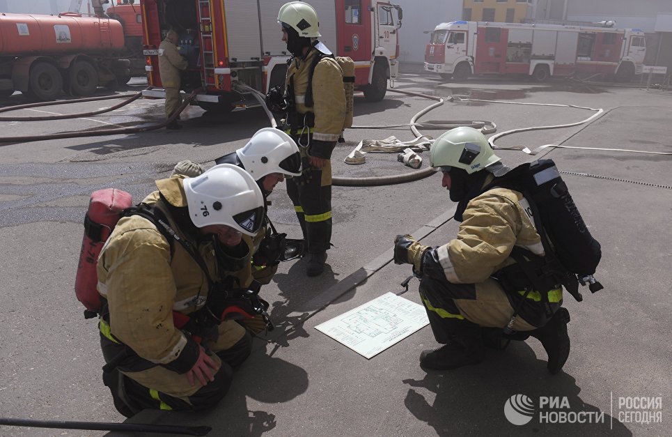 Сотрудники МЧС у здания торгового центра Порт в Казани, где произошло возгорание