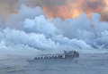 Пассажиры прогулочного катера наблюдают извержение вулкана Килауэа на Гавайях Пассажиры прогулочного катера наблюдают извержение вулкана Килауэа на Гавайях