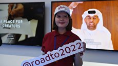 Волонтер с табличкой #@roadto2022 на открытии павильона Мажлис Катар на Пушкинской набережной в Центральном парке культуры и отдыха имени Горького в Москве Волонтер с табличкой #@roadto2022 на открытии павильона Мажлис Катар на Пушкинской набережной в Центральном парке культуры и отдыха имени Горького в Москве