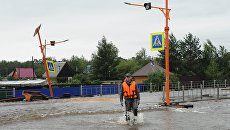 Сотрудник МЧС на затопленной в результате паводка улице в городе Чите. Архивное фото Сотрудник МЧС на затопленной в результате паводка улице в городе Чите. Архивное фото
