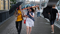 Прохожие на Крымском мосту во время дождя в Москве. Архивное фото Прохожие на Крымском мосту во время дождя в Москве. Архивное фото