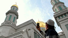 Мусульманин фотографирует Московскую соборную мечеть в день Курбан-байрама. 21 августа 2018 Мусульманин фотографирует Московскую соборную мечеть в день Курбан-байрама. 21 августа 2018