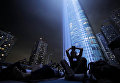 Жители Нью-Йорка наблюдают за световой инсталляцией под названием Tribute in Light Жители Нью-Йорка наблюдают за световой инсталляцией под названием Tribute in Light