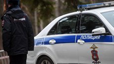 Сотрудник полиции возле служебного автомобиля. Архивное фото Сотрудник полиции возле служебного автомобиля. Архивное фото